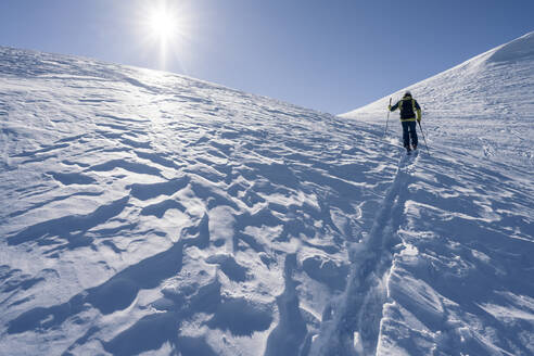 Mann im Gegenlicht auf Skitour, Graubünden, Schweiz - HBIF00025