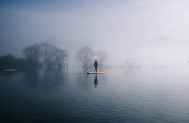 Frau Stand Up Paddle Surfing auf einem See - DGOF00312