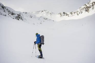 Man on an excursion in snowy mountains, Lombardy, Valtellina, Italy - MCVF00214