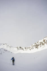 Mann auf einem Ausflug in verschneiten Bergen, Lombardei, Valtellina, Italien - MCVF00215