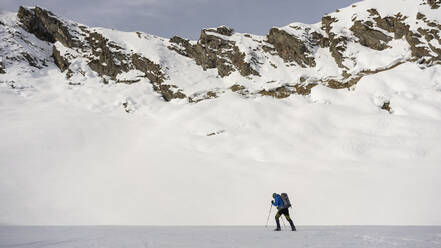 Mann auf einem Ausflug in verschneiten Bergen, Lombardei, Valtellina, Italien - MCVF00216