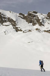 Mann auf einem Ausflug in verschneiten Bergen, Lombardei, Valtellina, Italien - MCVF00217
