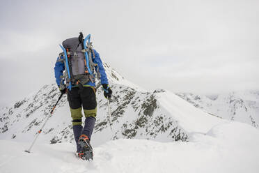 Man on an excursion on the crest of a snowy mountain, Lombardy, Valtellina, Italy - MCVF00220