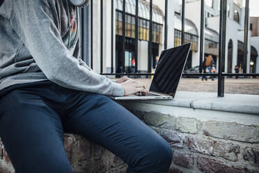 Jugendlicher mit Laptop in der Stadt - ANHF00208