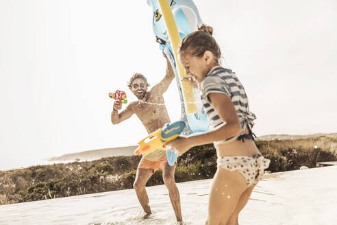 Father and daughter having a water fight - SDAHF00108