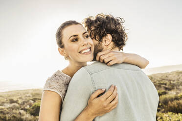 Happy young couple hugging at the coast in summer - SDAHF00139