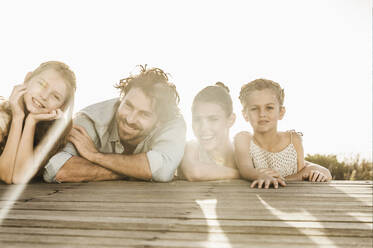 Porträt einer Familie auf der Terrasse bei Sonnenuntergang - SDAHF00146