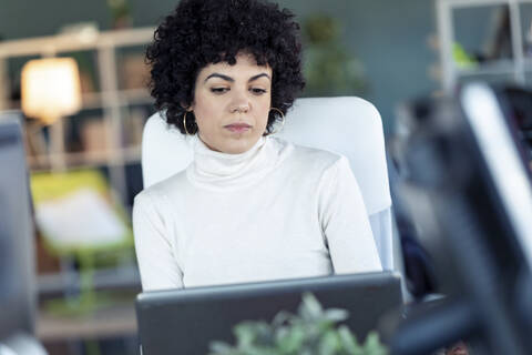 Unternehmerin mit Laptop in einem Büro, lizenzfreies Stockfoto