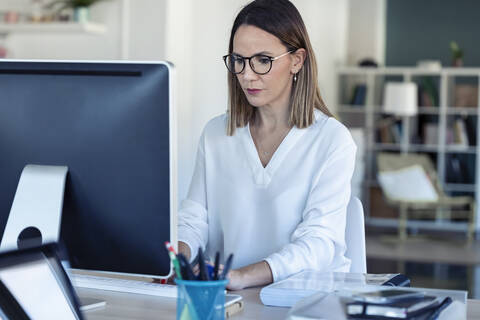 Unternehmerin mit Laptop im Büro, lizenzfreies Stockfoto