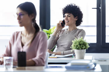 Businesswoman phoning at the office - JSRF00874