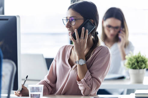 Businesswoman phoning at the office - JSRF00878