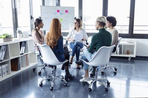 Geschäftsfrauen während einer Sitzung an einem Flipchart - JSRF00888