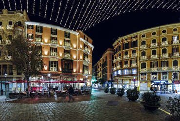 Spanien, Balearische Inseln, Palma de Mallorca, Gebäude und Straßencafé bei Nacht beleuchtet - AMF07821