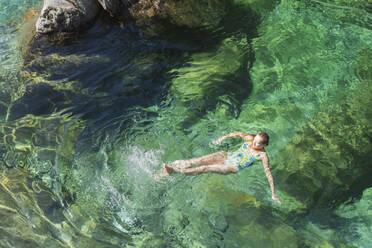 Frau schwimmt im erfrischenden Fluss Verszasca - GWF06418