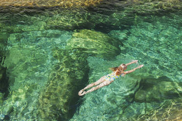 Frau schwimmt im erfrischenden Fluss Verszasca - GWF06419