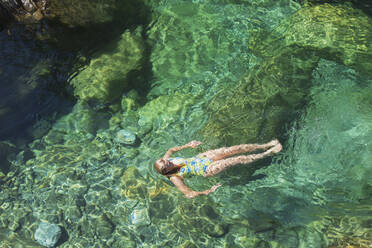 Frau schwimmt im erfrischenden Fluss Verszasca - GWF06420