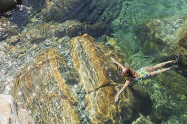 Frau schwimmt im erfrischenden Fluss Verszasca - GWF06421