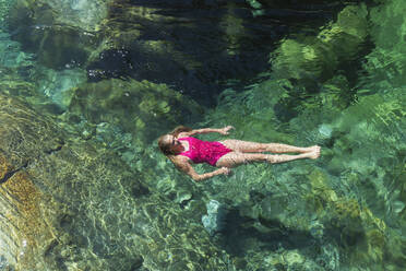 Frau schwimmt im erfrischenden Fluss Verszasca - GWF06422