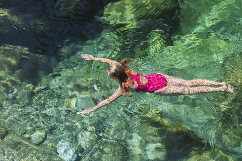 Frau schwimmt im erfrischenden Fluss Verszasca, lizenzfreies Stockfoto