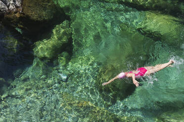 Frau schwimmt im erfrischenden Fluss Verszasca - GWF06426