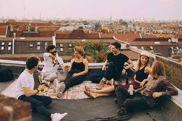 Glückliche Freunde genießen ein Bier auf der Terrasse einer Dachterrassenparty in der Stadt - MASF16688