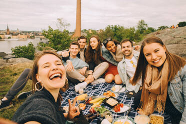 Porträt von männlichen und weiblichen Freunden, die sich bei einem Picknick am Wochenende amüsieren - MASF16716
