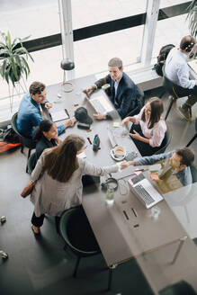 Blick aus einem hohen Winkel auf ein Team von Fachleuten, die sich im kreativen Coworking Space die Hände schütteln - MASF16726