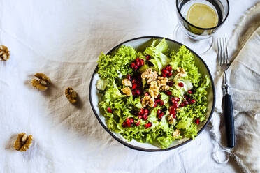 Schüssel mit grünem Salat mit Walnüssen und Granatapfelkernen - SBDF04191