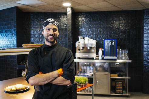 Portrait of smiling chef in restaurant kitchen - DGOF00355