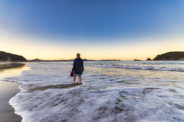 Frau am Hahei Beach bei Sonnenaufgang, Waikato, Nordinsel, Neuseeland - SMAF01831