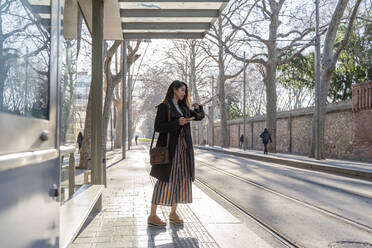 Young woman waiting at the tram stop - AFVF05292