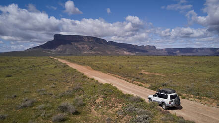 South Africa, Western Cape, Blanco, Aerial view of white 4x4 driving on dirt track - VEGF01525