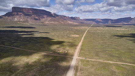 Südafrika, Western Cape, Blanco, Luftaufnahme eines weißen Geländewagens, der auf einem Feldweg in Richtung Berge fährt - VEGF01556