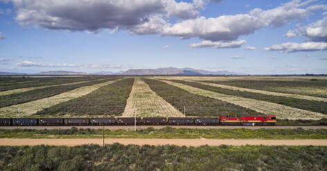 South Africa, Western Cape, Aerial view of cargo train passing by fields - VEGF01560