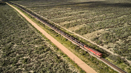 South Africa, Western Cape, Aerial view of cargo train passing by fields - VEGF01562