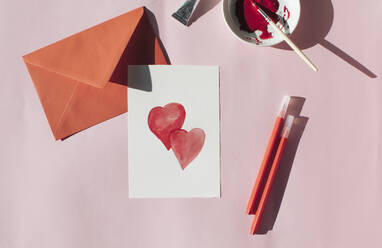 Herstellung einer Valentinstagskarte, roter Umschlag und Karte mit Herzen - MOMF00835