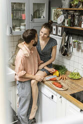 Zärtliches Paar in der Küche, das Essen zubereitet - PESF01784