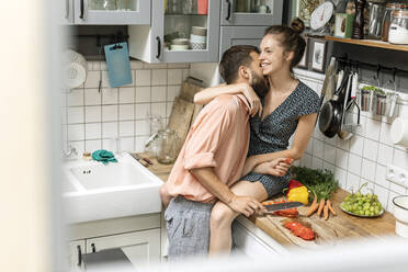 Zärtliches Paar in der Küche, das Essen zubereitet - PESF01785