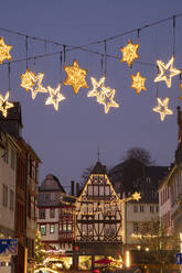 Germany, Hesse, Limburg an der Lahn, Christmas decorations glowing over market square at dusk - WIF04182