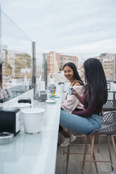 Zwei glückliche junge Frauen in einem Dachcafé - MPPF00494