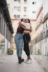 Two happy young women hugging in the city - MPPF00503