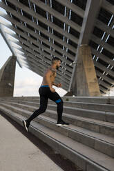 Jogger, der während des Trainings in Barcelona, Spanien, auf einer Stufe läuft - MAUF03336