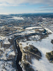 Russland, Leningrader Gebiet, Tichwin, Luftaufnahme des Flusses Tichwinka und der Stadt im Winter - KNTF04389