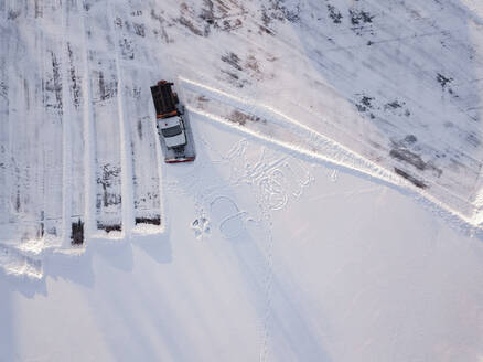 Russland, Leningrad Oblast, Tichwin, Luftaufnahme eines Schneepflugs beim Räumen eines Parkplatzes - KNTF04402