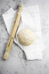 Rolling pin, pizza dough and white napkin - GIOF07971