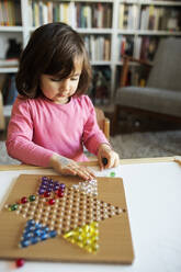 Kleines Mädchen spielt mit Murmeln auf dem Tisch - VABF02621
