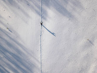 Russland, Leningrad Oblast, Tichwin, Luftaufnahme eines einsamen Skifahrers im Winter - KNTF04409