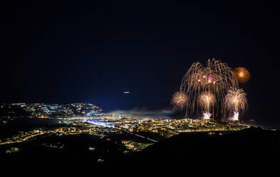 Spanien, Granada, Almunecar, Beleuchtete Stadt und Feuerwerk bei Nacht - LJF01302