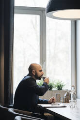 Businessman drinking coffee in a cafe - AHSF01865