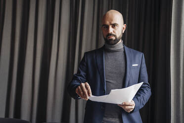 Businessman working in a cafe, holding documents - AHSF01887